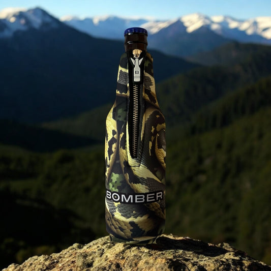 Bomber Venom AI Snake 12oz zippered 4mm neoprene bottle insulator in olive green camo snake print on a mountain summit