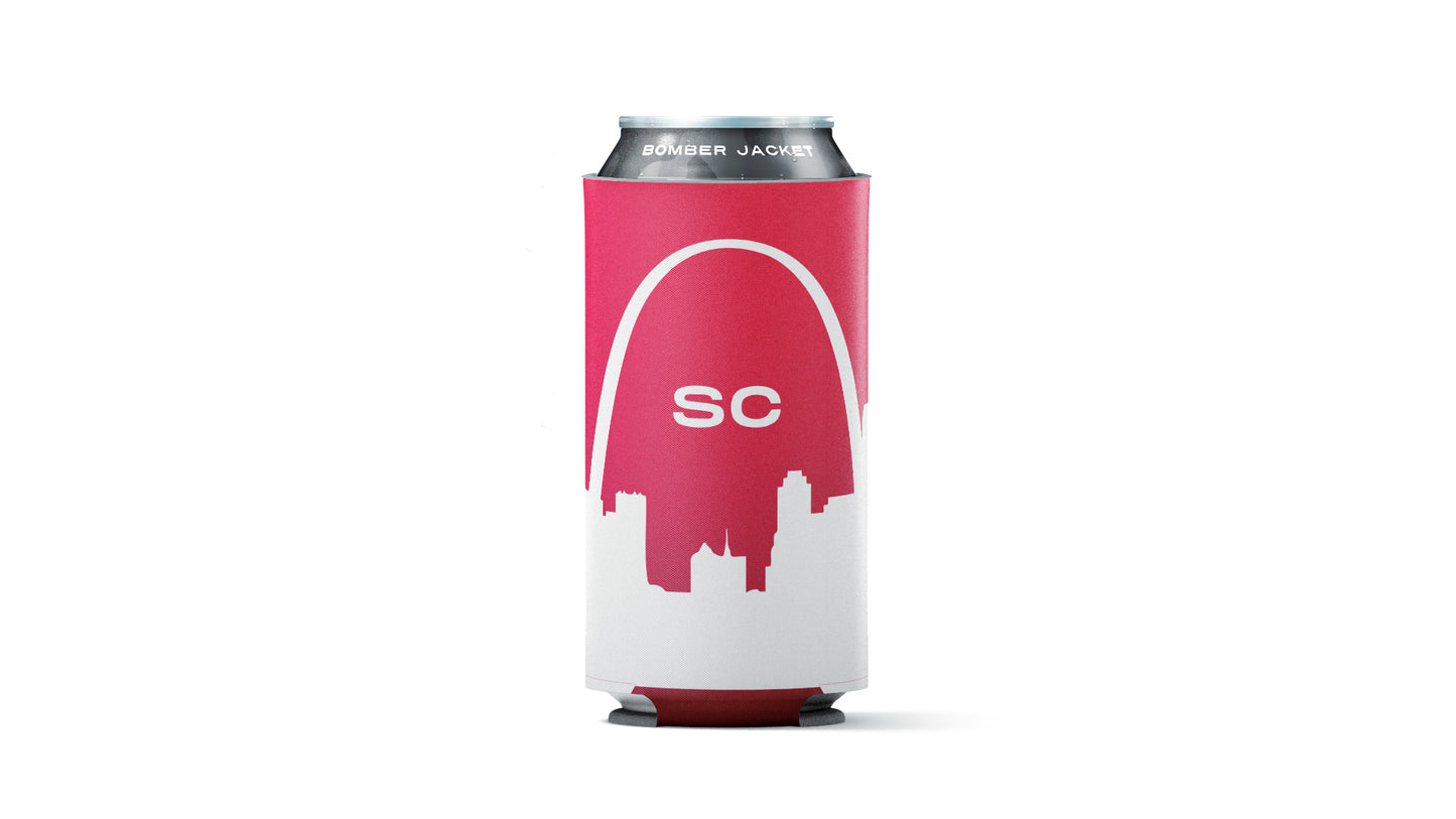 A red and white can cooler sleeve holding a silver aluminum beverage can, shown against a plain white background. The sleeve features a white arch graphic over a red silhouette of the Saint Louis skyline, with the letters 'SC' in white in the center.