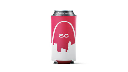 A red and white can cooler sleeve holding a silver aluminum beverage can, shown against a plain white background. The sleeve features a white arch graphic over a red silhouette of the Saint Louis skyline, with the letters 'SC' in white in the center.