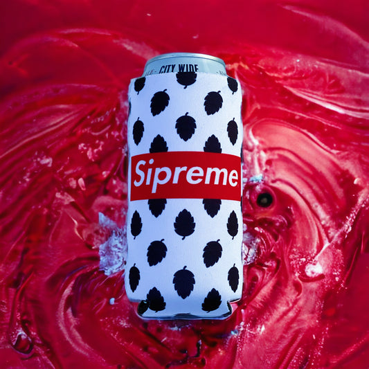 A white can cooler sleeve with black leaf-like spots and a red Supreme box logo, holding a silver can, set against a swirling red liquid background.